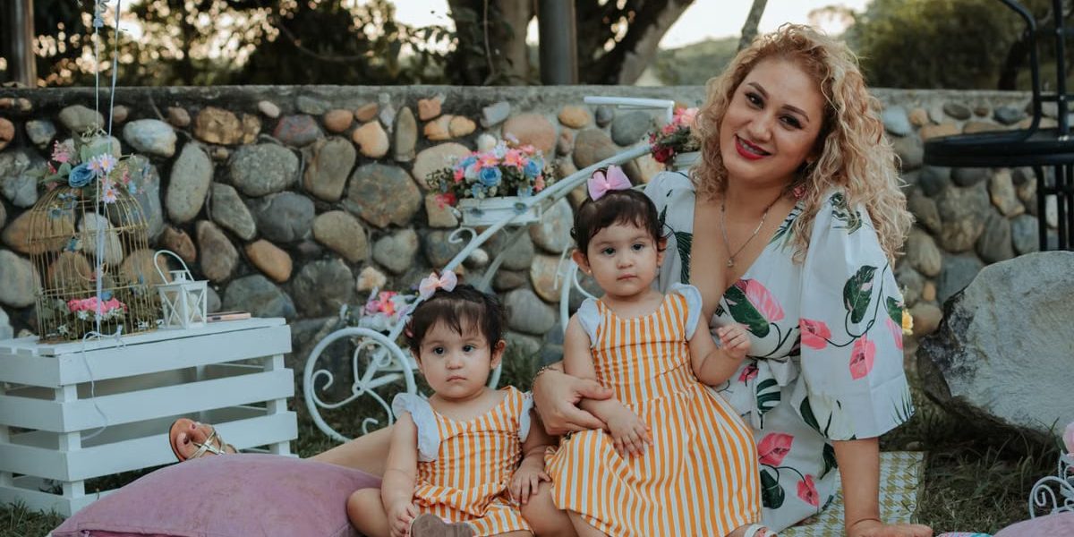 A joyful family picnic in La Dorada, Colombia featuring a mother and her two children outdoors.