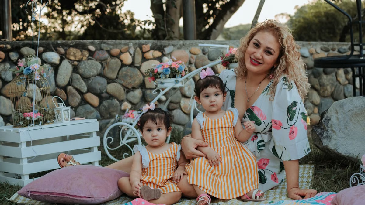 A joyful family picnic in La Dorada, Colombia featuring a mother and her two children outdoors.