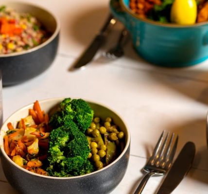 Delicious colorful bowls of salad and fresh beverages on a white table, perfect for healthy dining.