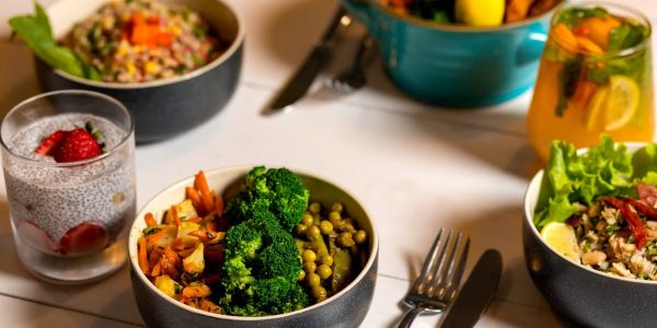 Delicious colorful bowls of salad and fresh beverages on a white table, perfect for healthy dining.