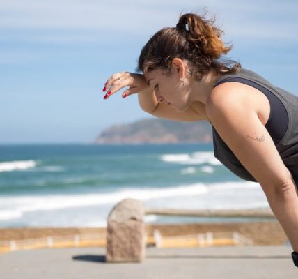 A woman rests after exercise, overlooking the ocean in Portugal's scenic seascape.